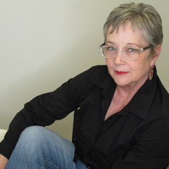 Kim wearing a black top and clear glasses